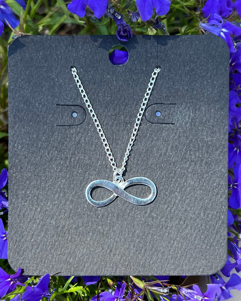 Silver-plated infinity necklace among flowers